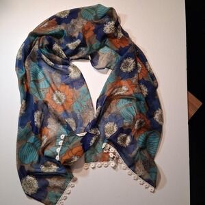 Fossil scarf with blue, orange, and teal floral and leaf design white pom-poms